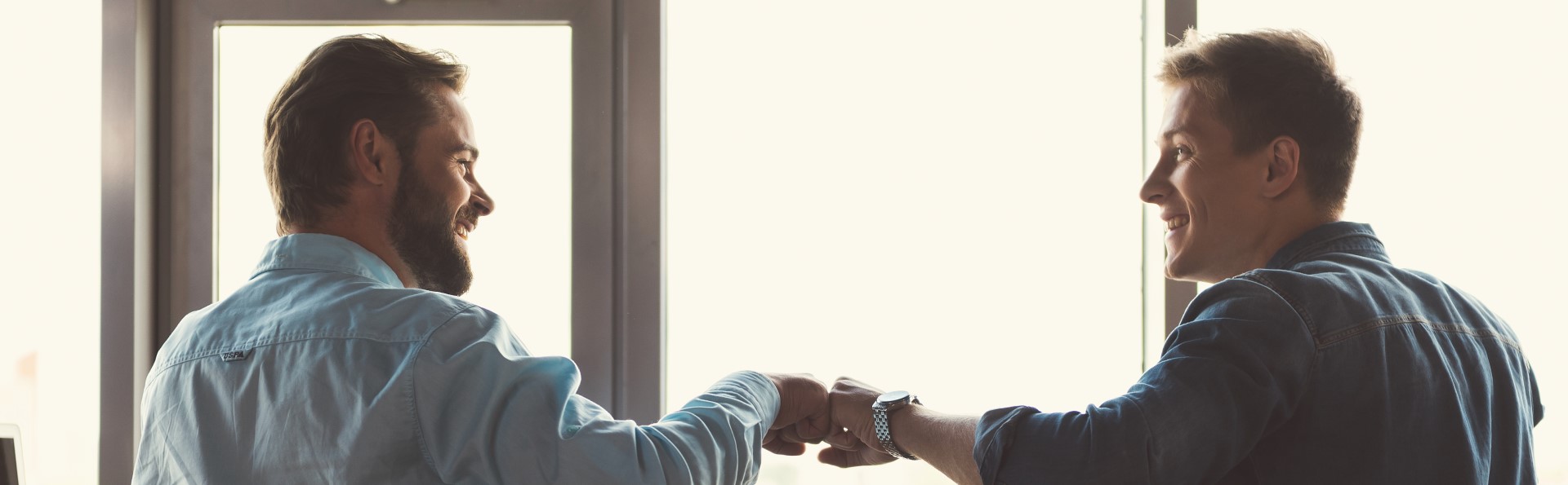 Two men fistbumping in a coffee shop