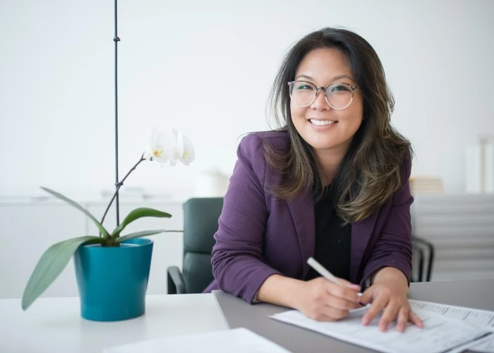 Asian lady writing on a document